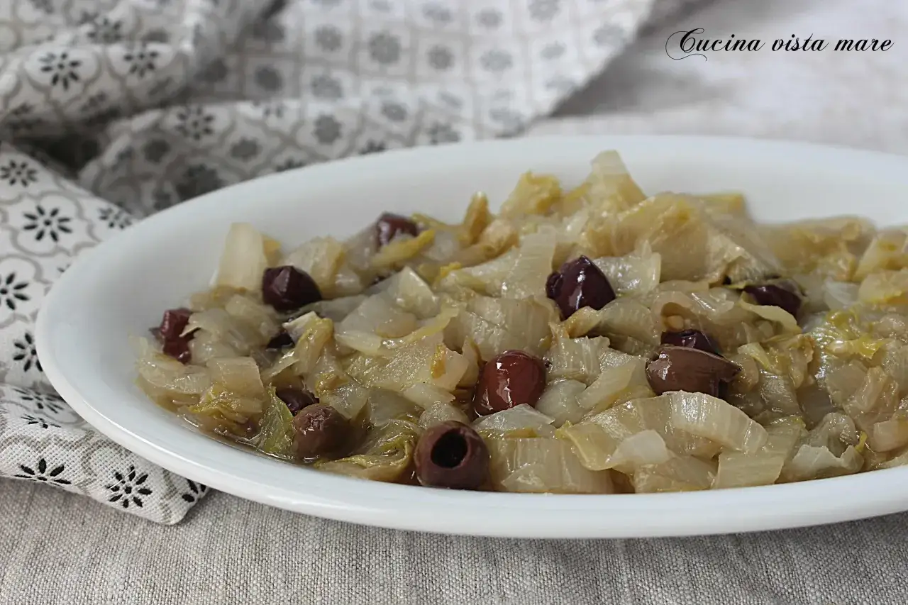 Indivia belga cotta in padella con olive nere, un piatto semplice e gustoso.