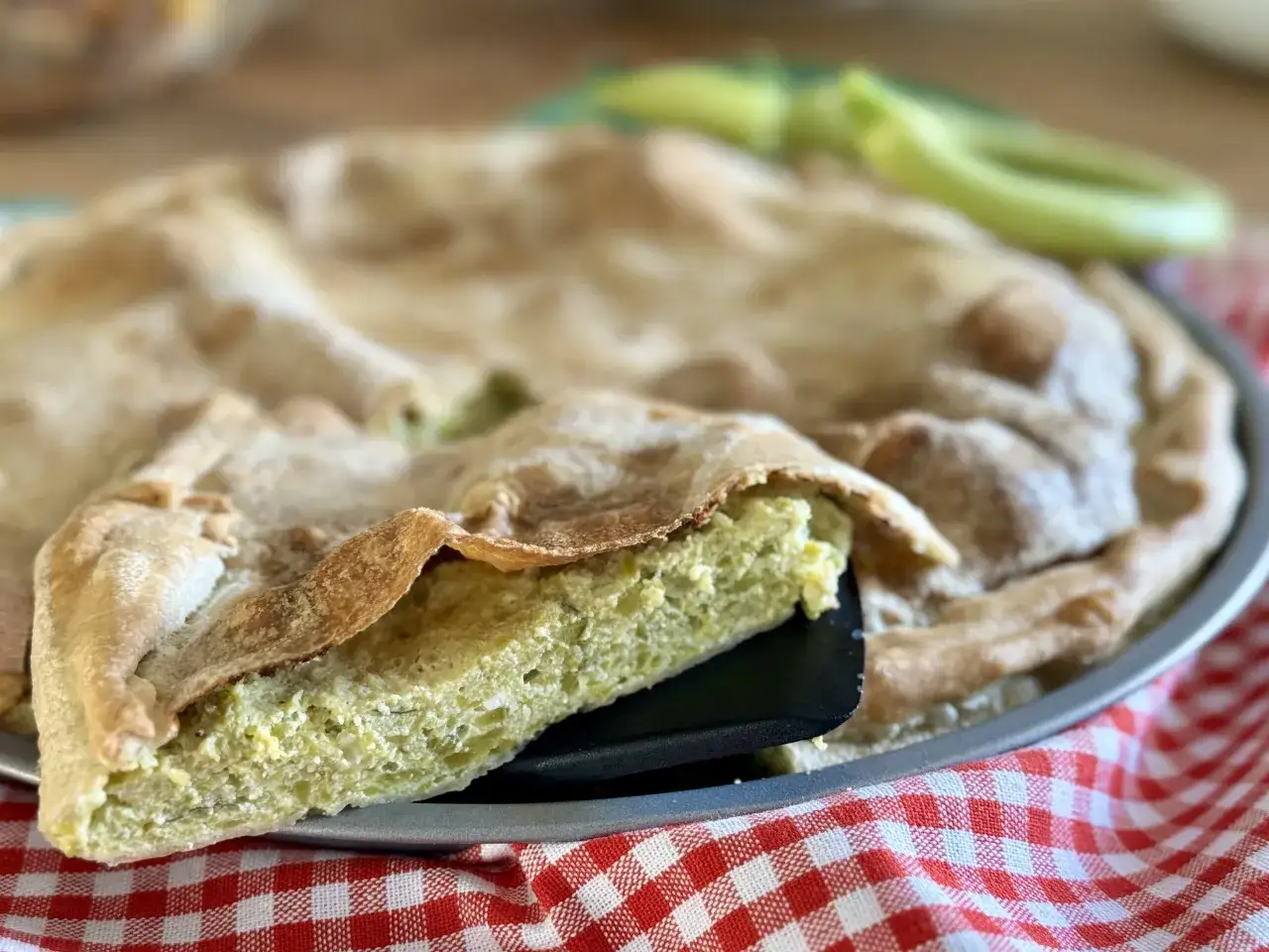 Una fetta di torta di riso e zucchine alla ligure, con la sua crosta dorata e il ripieno verde e invitante, pronta per essere gustata.