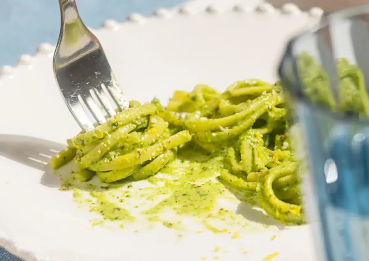 Un primo piatto di pasta fresca condita con un cremoso pesto al limone, pronto per essere gustato.