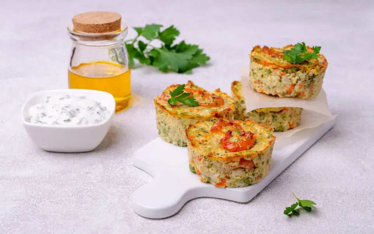 Tortino di zucchine con gamberetti, servito con salsa e olio.