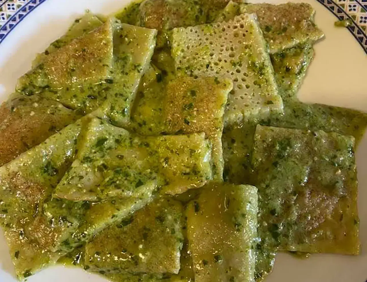 Testaroli al pesto, una deliziosa ricetta tradizionale. Piatto di pasta sottile e morbida, condita con un pesto verde brillante.