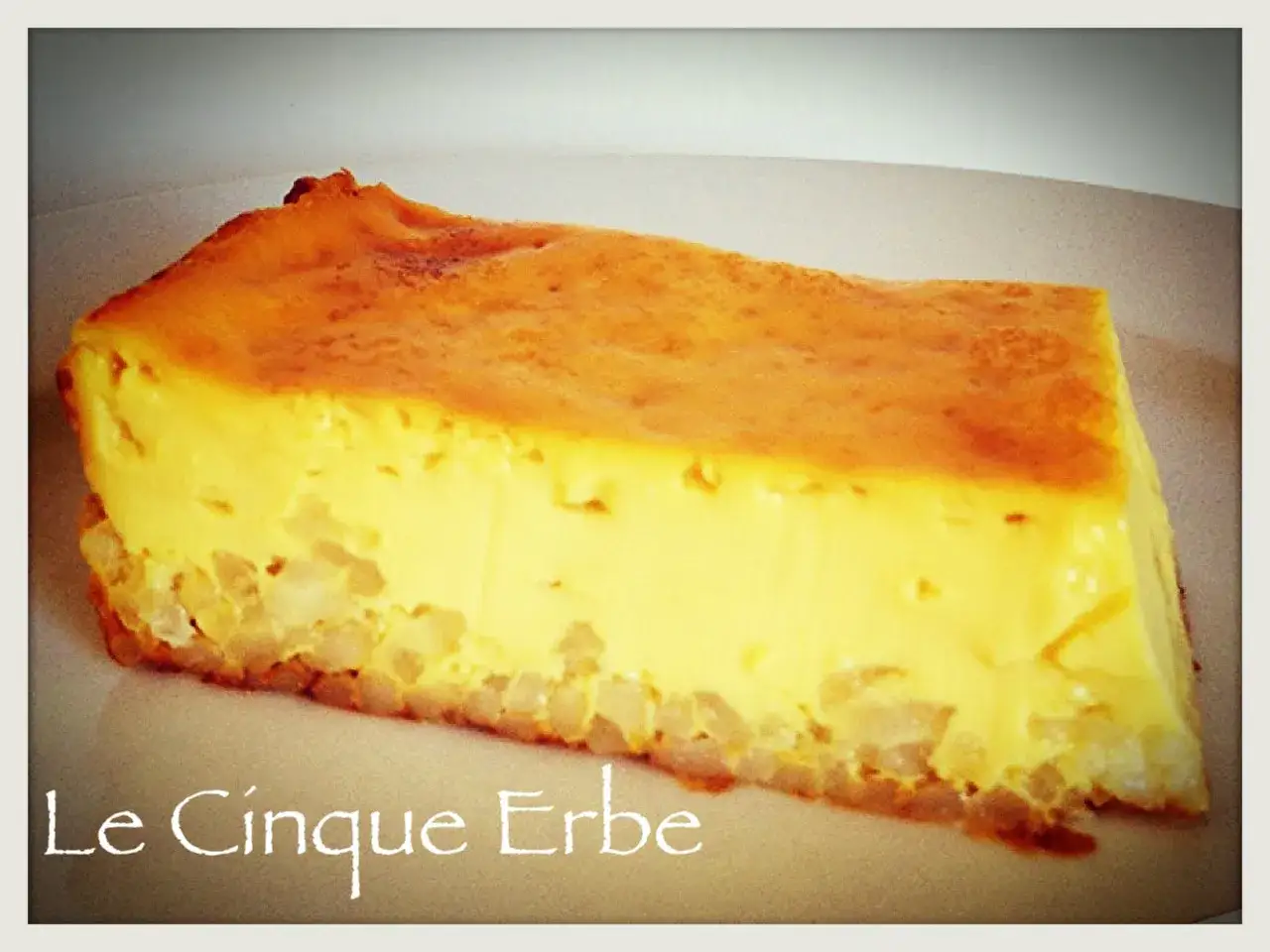 Una fetta di torta di riso salata, con una base croccante e un ripieno cremoso e dorato.
