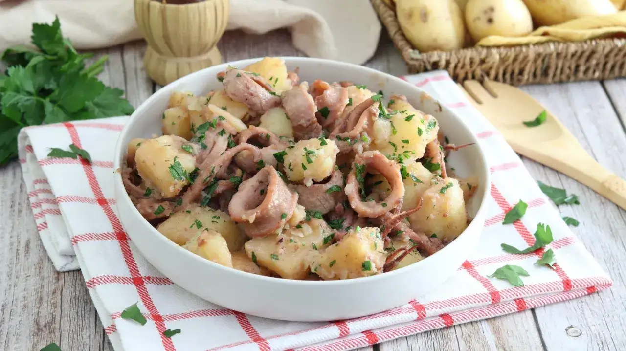 Un invitante piatto di totani e patate, condito con prezzemolo fresco, pronto per essere gustato.