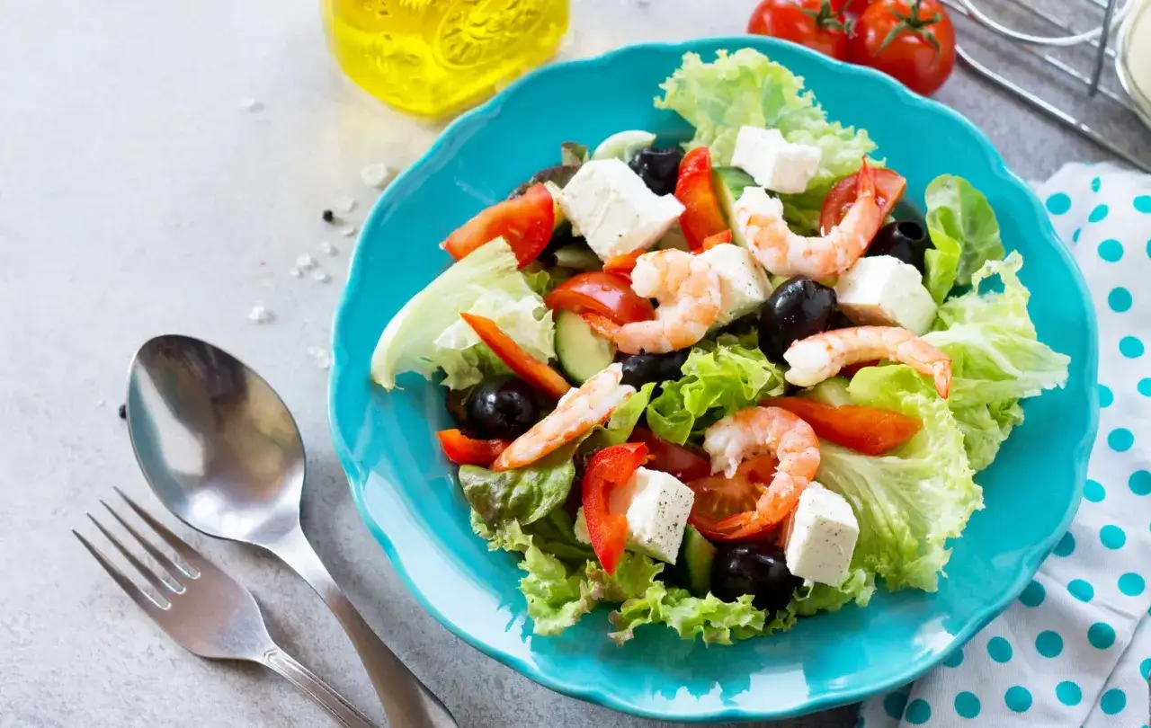 Insalata greca con gamberi, feta, olive e pomodori. Perfetta per ricette cetrioli crudi fresche e leggere.
