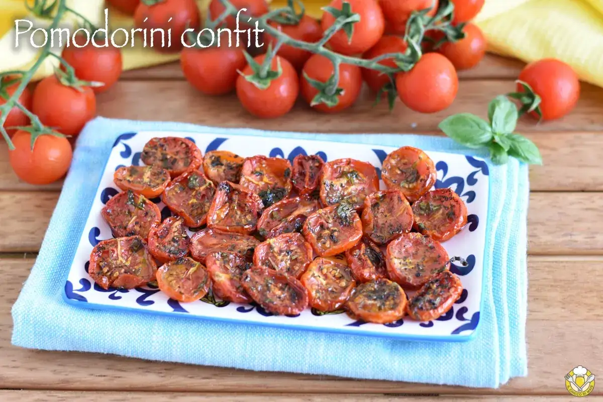Pomodorini confit dorati e succosi, conditi con erbe aromatiche, pronti per insaporire ogni piatto.