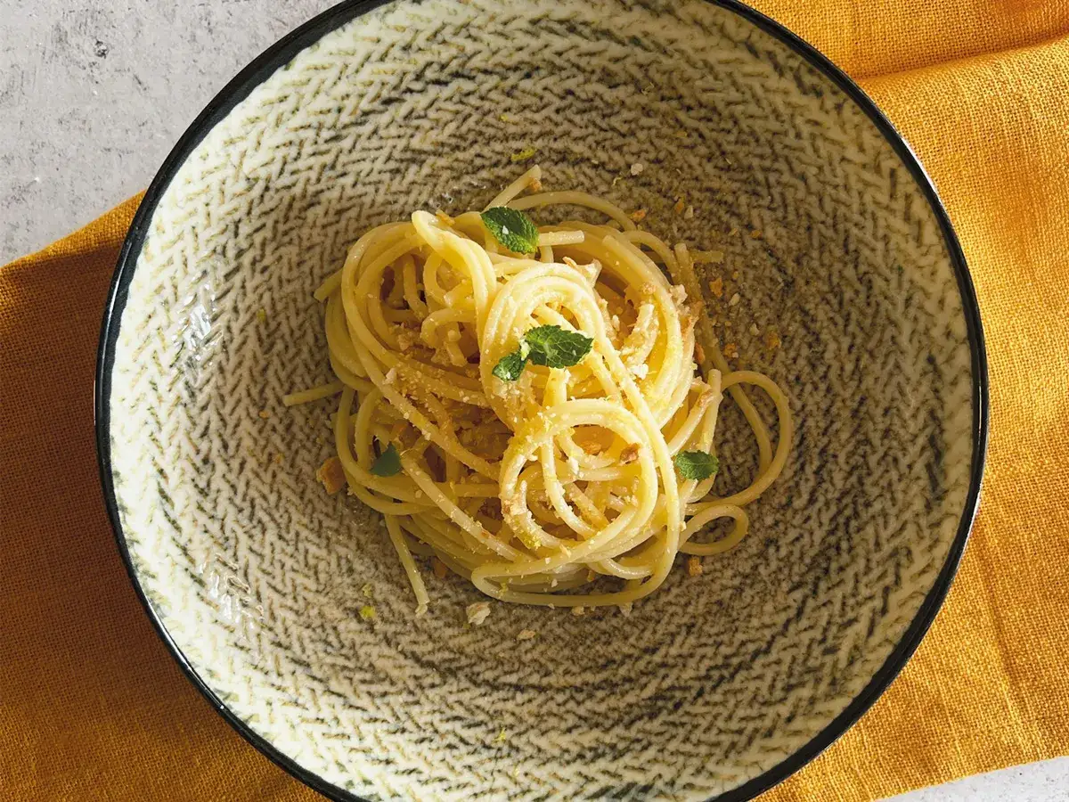 Spaghetti al limone, un assaggio della ricetta della Costiera Amalfitana, guarniti con menta fresca e scorza di limone.