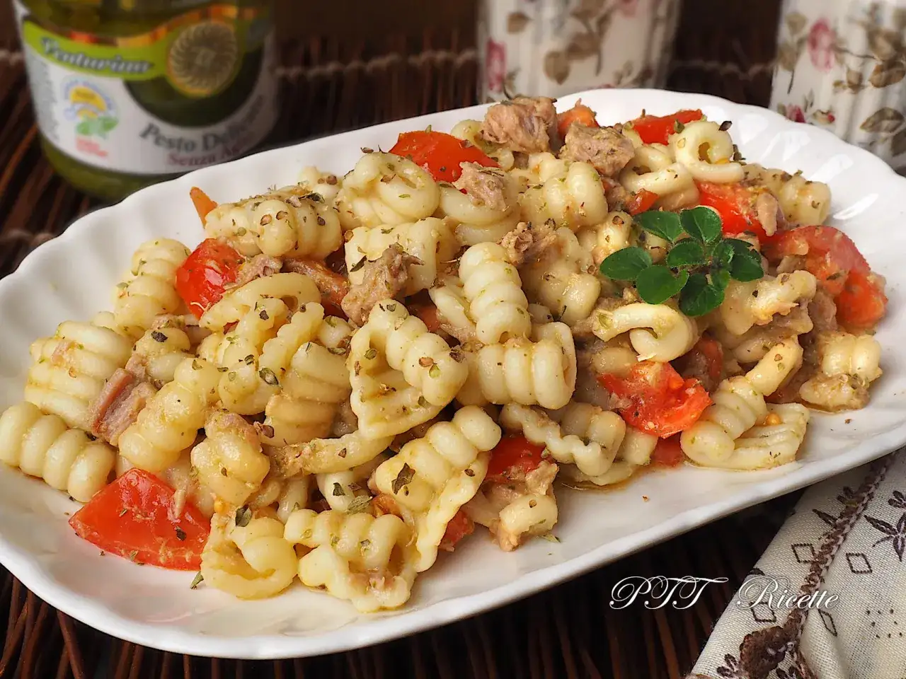 Pasta estiva veloce con tonno e pomodorini, condita con erbe aromatiche. Un piatto fresco e saporito, perfetto per le giornate calde.