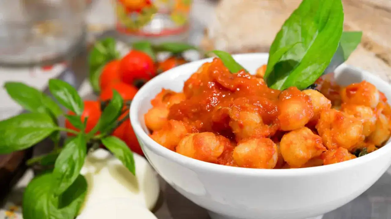Gnocchi di ricotta soffici e saporiti, conditi con un sugo rosso e guarniti con basilico fresco.