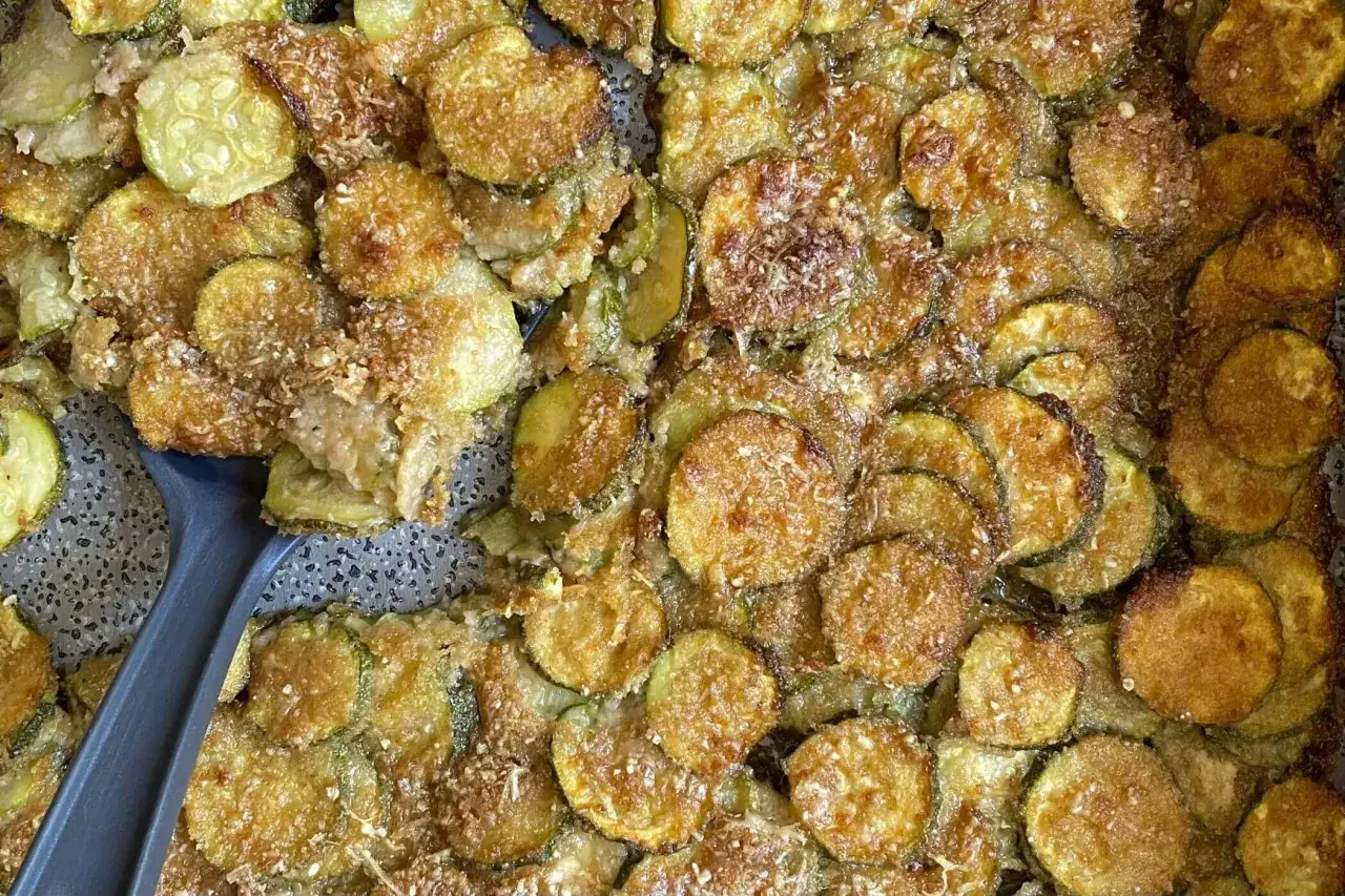 Fette di zucchine al forno dorate e croccanti, condite con parmigiano e pangrattato. Un contorno saporito e facile da preparare.