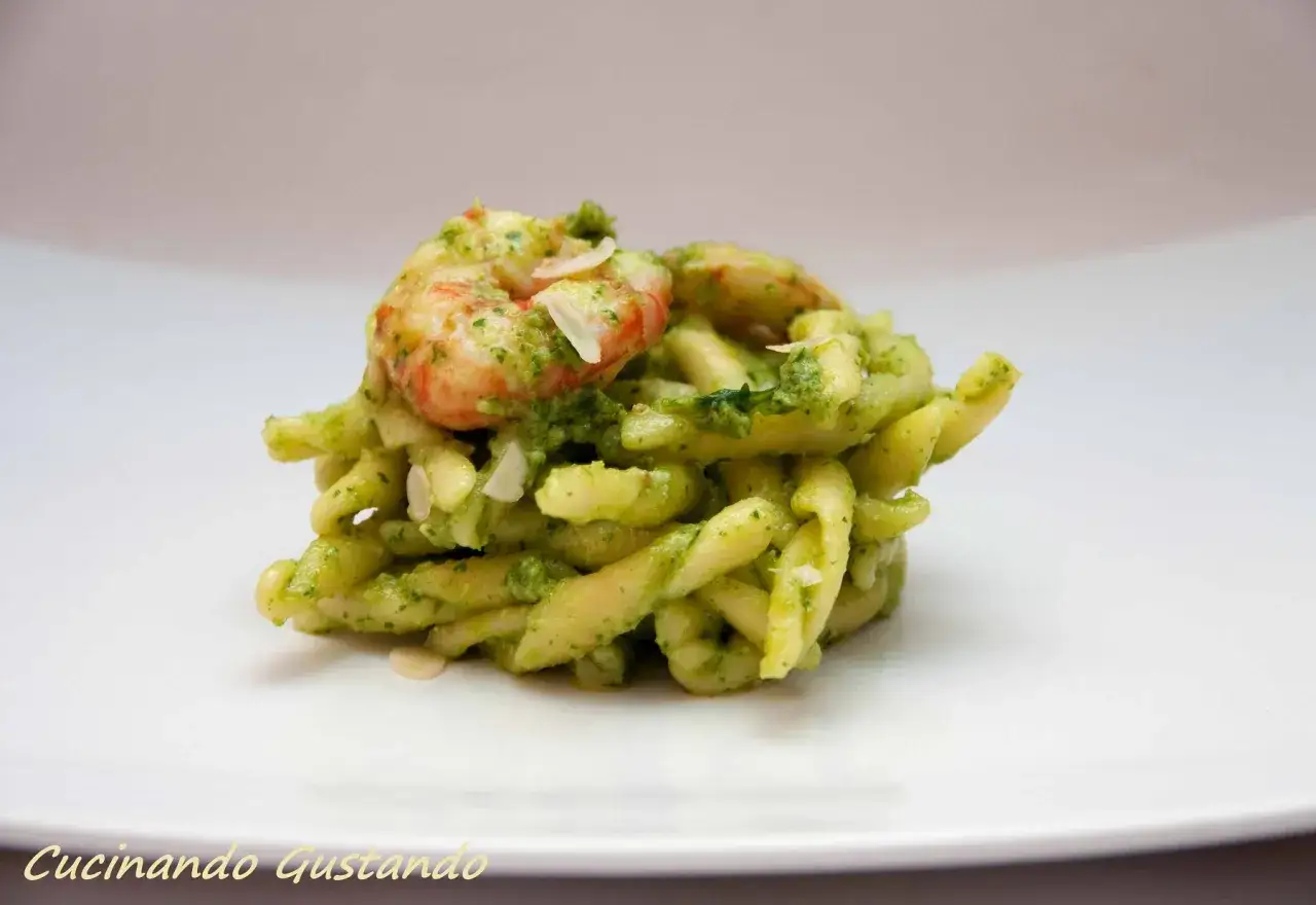 Pasta con gamberi e un delizioso pesto di rucola e mandorle, guarnita con lamelle di mandorle.
