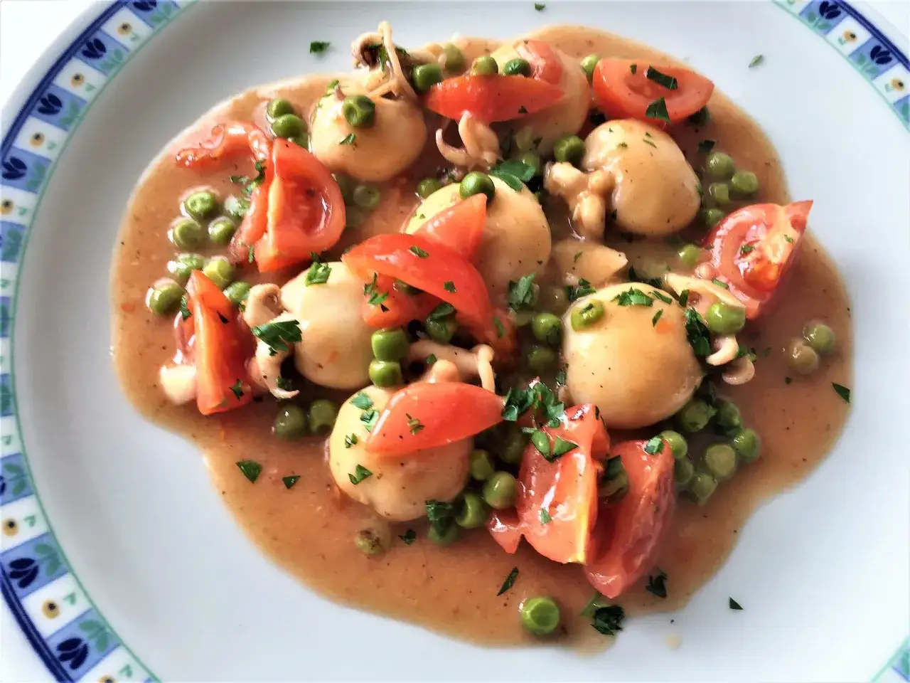 Seppioline surgelate con piselli e pomodoro, un piatto gustoso e colorato, pronto per essere gustato.