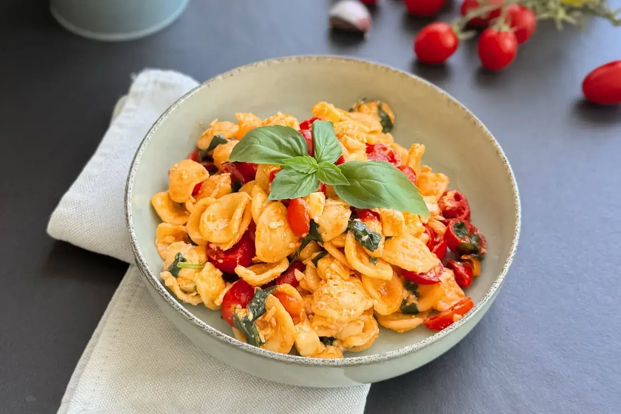 Orecchiette con pomodorini freschi, basilico e un tocco di ricotta salata, un delizioso piatto di pasta alla crudaiola.