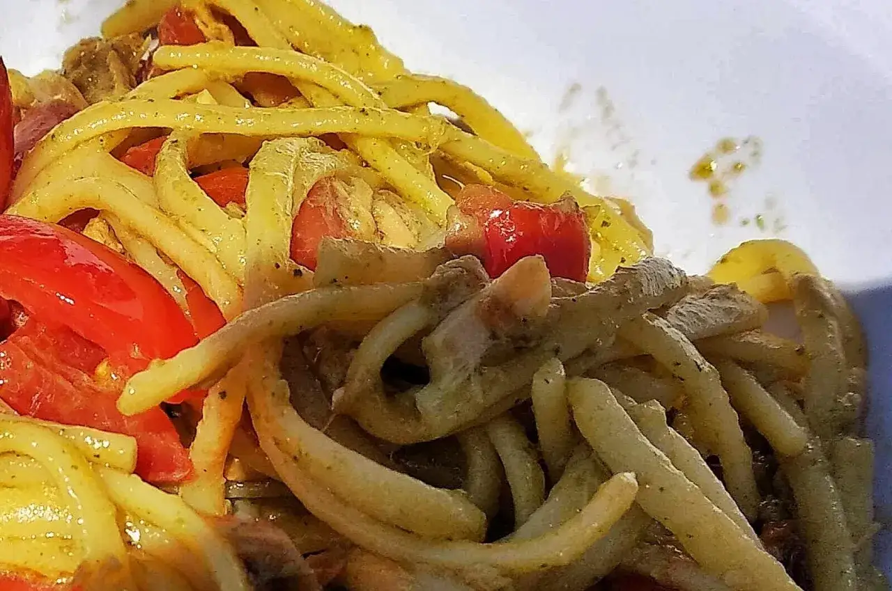 Un primo piatto saporito: pasta alla carlofortina con pomodorini freschi e un condimento verde.