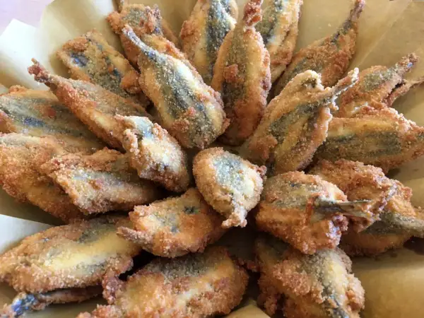 Un piatto invitante di acciughe ripiene alla ligure, dorate e croccanti, pronte per essere gustate.