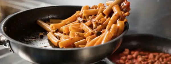 Rigatoni conditi con un sugo ricco e saporito, pronti per essere serviti. Un classico piatto di pasta al pomodoro che fa venire l'acquolina in bocca.