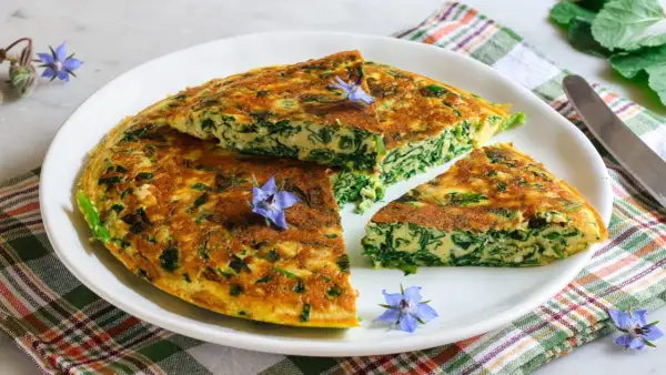 Frittata di borragine, un'idea gustosa per le tue ricette con erbe selvatiche. Guarnita con fiori di borragine.