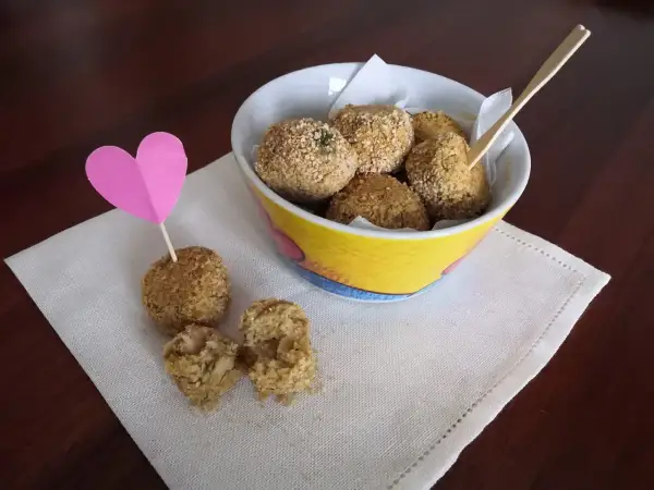 Deliziose polpette di ceci, croccanti fuori e morbide dentro, servite in una ciotola colorata con un cuore rosa.