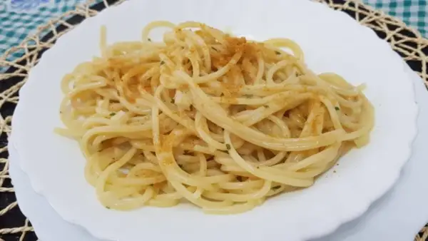 Spaghetti conditi con un filo d'olio, aglio e prezzemolo, spolverati con la preziosa bottarga.