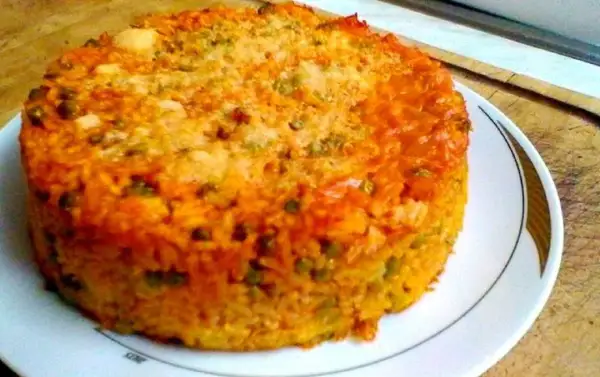 Timballo di riso dorato e invitante, con piselli e una crosticina croccante, pronto per essere gustato.