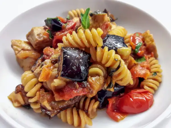 Fusilli con pesce spada, melanzane, pomodorini e basilico, un piatto estivo saporito e colorato.