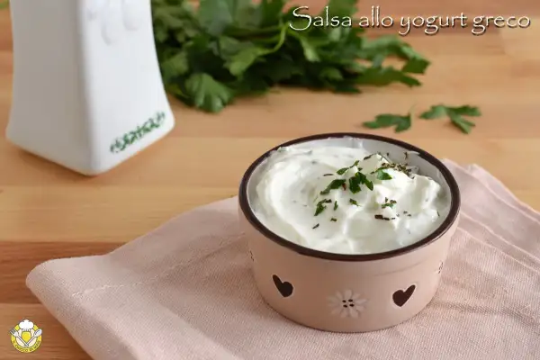 Salsa allo yogurt greco cremosa, guarnita con prezzemolo fresco, perfetta per insalate leggere e gustose.