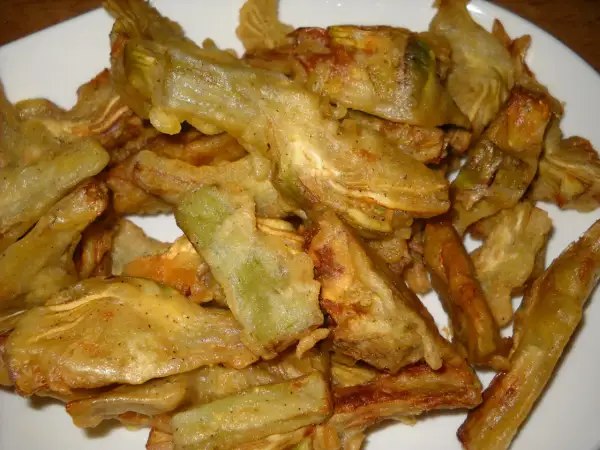 Piatto di carciofi fritti senza pastella, dorati e croccanti, pronti per essere gustati.