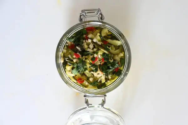 Barattolo di zucchine sott'olio con aglio, peperoncino e erbe aromatiche.