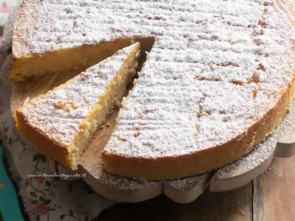 Torta di riso ricetta: una fetta di torta soffice e dorata, cosparsa di zucchero a velo, pronta per essere gustata.