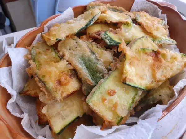 Fette dorate di zucchine in pastella, croccanti e invitanti, pronte per essere gustate.