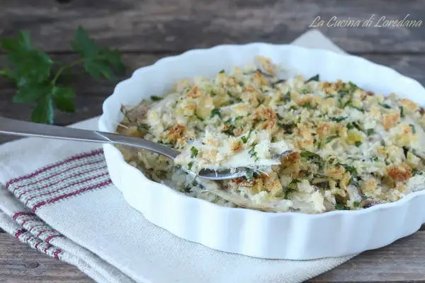 Un invitante tortino di alici gratinato, con croccante pangrattato e prezzemolo fresco, pronto per essere gustato.