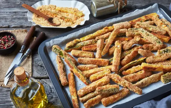 Bastoncini croccanti di zucchine al forno, pronti per essere gustati. Un contorno sfizioso e leggero.